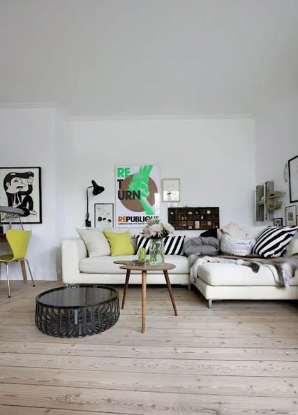 balta sofa, baltos sienos, paveikslai, medinis staliukas