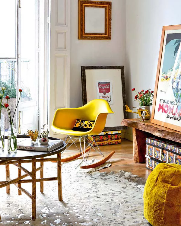 geltonas supuojantis fotelis, pufas, paveikslai svetainėje